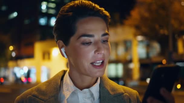 Bizneswoman Patrząc Ekran Smartfona Nocy Zbliżenie Zrelaksowana Kobieta Słucha Muzyki — Wideo stockowe
