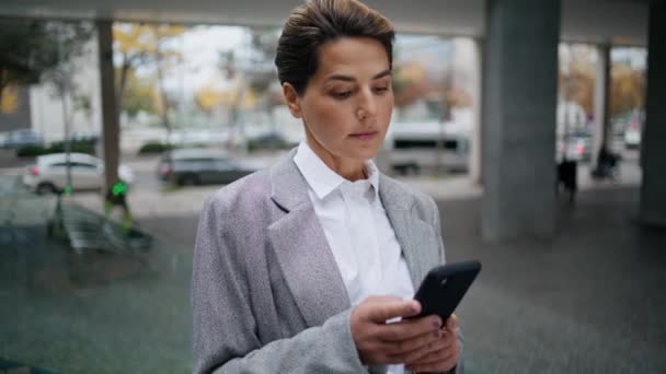 Seriöse Geschäftsfrau Mit Smartphone Auf Der Straße Konzentrierte Frau Tippt — Stockvideo