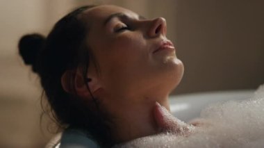 Tembel kız lüks banyonun keyfini çıkarıyor. Tasasız kadın banyo yapıyor. Otel içlerindeki mumlarda, yumuşak ciltleri yıkayan bir kadın. Model temizleyici vücut. Gevşeme zamanı kavramı