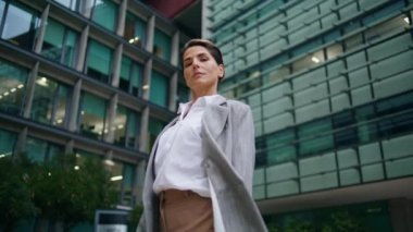 Şehir merkezinde başarılı bir CEO yürüyüşü. Kendine güveni tam orta yaşlı bir iş kadını çağdaş şehir binasında kurumsal müşteri toplantısına gidiyor. Düşünceli finans müdürü bayan lider takım elbiseli kamera gibi görünüyor..