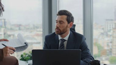 Mutlu başarılı iş ortakları detaylar üzerinde hemfikir. Çalışma projesi lüks şirket ofisinde birlikte oturuyoruz. Yakın çekim. Kadın belgeleri okurken, sakallı çekici CEO iş adamı dizüstü bilgisayarda çalışıyor..