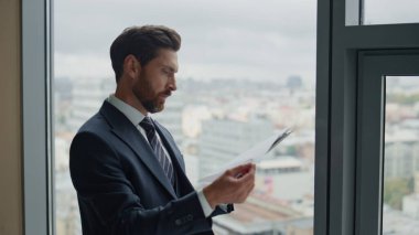 Ofis penceresinin önünde mali belgeleri kontrol eden profesyonel kendine güvenen denetçi. Tatmin olmuş iş adamı pasta grafiğiyle muhasebe raporunu okurken gülümsüyor. Mutlu hisseden adam kar elde eder..