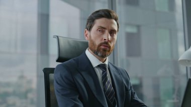 Modern ofiste oturan verileri analiz eden bilgisayar daktilo belgelerinde çalışan profesyonel CEO yöneticisi. Düşünceli sakallı iş adamı dizüstü bilgisayara bakarak şirket planlaması yapıyor. İş konsepti.