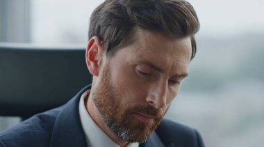 Şirket ofisinde oturan ciddi mali problemler yüzünden kapatılıyor. Kariyerinde ilerlemeyi düşünen odaklanmış sakallı bir menajerin portresi. Düşünceli işadamı şirket karları üzerinde çalışıyor..