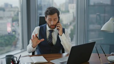 Kendine güvenen sakallı danışman. Masadaki not defterine telefon görüşmesiyle randevu alıyor. Akıllı telefondan konuşurken dizüstü bilgisayar kullanmakla meşgul. Modern ofiste başarılı bir girişimci..