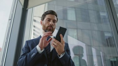 Stresli iş adamı, panoramik pencerenin yanında kötü bir telefon konuşmasını sonlandırıyor. Endişeli proje yöneticisi akıllı telefon konuşmasını içeride bitirdi. Seçkin CEO ofis işinden dolayı umutsuzluğa düştü.