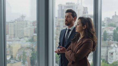 Kendine güvenen sakallı işadamı kadın yöneticiyle konuşuyor. Yeni iş projesini yakından gösteriyor. İş perspektiflerinin gelişiminden bahseden iki genç meslektaş. İş arkadaşları sohbetten hoşlanır.