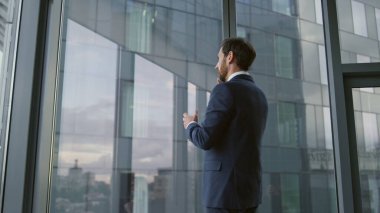 Kendine güvenen akıllı işadamı, modern ofisteki akıllı telefonu kullanarak iş ortaklarını arıyor. Sakallı finans müdürü telefon şirketinin sorunlarını çözmekten bahsediyor. Patron telefonda konuşuyor..
