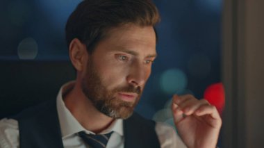 Çok çalışan sakallı şirket çalışanı gece geç saatlere kadar ofiste tek başına çalışıyor. Portre, dizüstü bilgisayarında stresli bir şekilde masa başında oturan odaklanmış finans müdürü ile meşgul. Yorgun iş adamı çözme sorunu