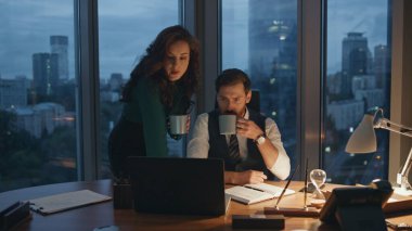 Ciddi iş ortakları kahve içerek gece geç saatlerde ofiste birlikte çalışırlar. İletişim şirketinde çalışan iki meslektaş karanlık kabine dağıtıyor. Yeni projeyi tartışan zeki iş arkadaşları takım çalışmasının keyfini çıkarıyorlar.