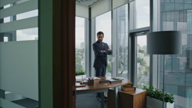 Kendine güvenen profesyonel yatırımcı modern ofiste duruyor ve iş projesine yatırım yapmayı düşünüyor. Düşünceli iş adamı şirketin mali sonuçlarını merak ediyor. Dolabın sahibi genel müdür..