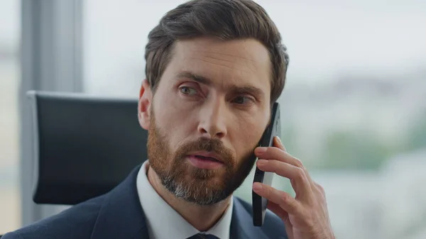 stock image Focused bearded business man calling partners using modern smartphone sitting office close up. Confident attractive company boss talking on mobile phone solving work issues. Ceo manager feeling busy.