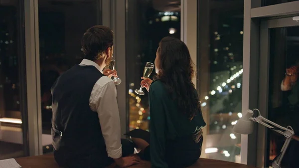 迷人的男人诱惑着调情的女人一起喝香槟庆祝成功的计划 情侣们谈情说爱 坐在全景窗前欣赏夜景 浪漫的概念 — 图库照片