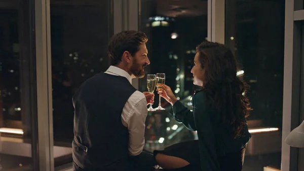 迷人的大胡子男人与微笑的女人调情 深夜在室内喝香槟 两个情人在一起享受浪漫 快乐的夫妻在夜景中愉快地交谈 — 图库照片