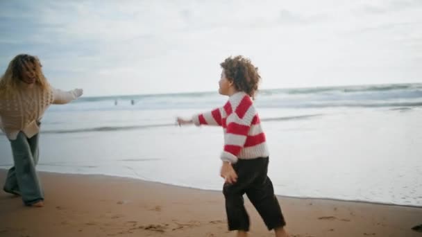 Lindo Hijo Corriendo Madre Otoño Junto Mar Feliz Niñera Abrazando — Vídeo de stock