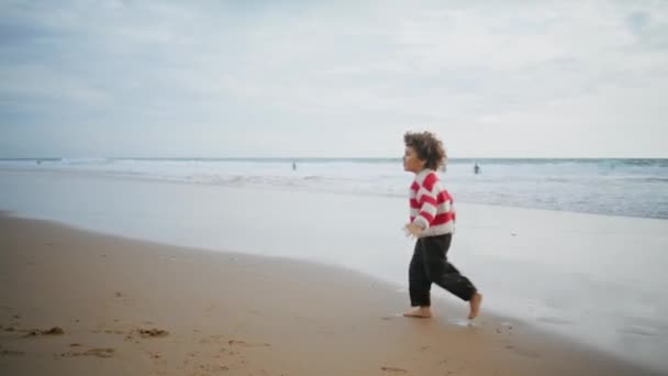 快乐的男孩赤脚在海滩上奔跑 快乐的儿子在秋节假期和美丽的母亲一起玩飞机飞行员游戏 可爱的卷曲的孩子和保姆在海滨休息 无忧无虑的童年概念 — 图库视频影像