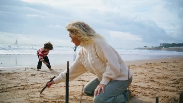 Familjeskrivande Strand Sand Tillsammans Kreativ Mor Son Vilar Havet Stranden — Stockvideo