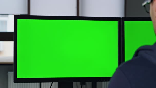 オフィスの閉鎖中の2台の緑のPcモニター プロのデザイナーマネージャーは クロマキーコンピュータを動作させます 開発者がソフトウェアコードを作成するという認識がない フリーランス編集プロジェクトの起動 — ストック動画