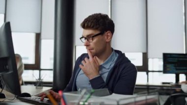 Bilgisayarcı ofiste ekrana bakıyor. Düşünceli mühendis kod sorununu kontrol ediyor. Javascript klavye analizi yapan dalgın bir uzman. Girişimci şirkette hata çözme konusunda uzmandır..