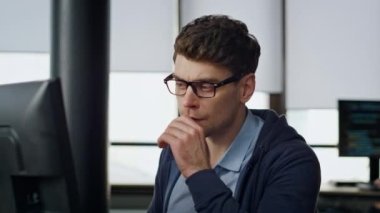 Odaklanmış yönetici, iş yerinde yakın çekimde ekrana bak. Yazılım kodlarını analiz eden ciddi bir programcı verileri kontrol ediyor. Düşünceli adam. Serbest çalışan. Fikir ve çözüm arayan bir ofis çalışanı. Geliştirici mühendisi