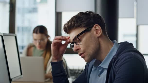 オフィスの閉鎖を開発してる 疲れ切った男プロジェクトマネージャー職場での眼の経験ひずみをこすります ストレスのかかるソフトウェアエンジニアのビジネスマンはコードの問題を熟考する スタートアップフリーランスの男 — ストック動画