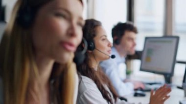 Telepazarlama ekibi birlikte çalışıyor. Gülümseyen kadın uzman müşteri danışmanı. Neşeli ajan sohbetleri talimatları verir. Hizmet operatörleri meslektaşları ofiste müşterilere yardım ediyor.