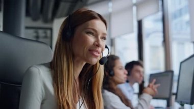 Dost canlısı bir kadın tele pazarlama merkezinde çalışıyor. Yardımcı satış müdürü ofiste kulaklık danışmanlığı yapan bir müşteriyle konuşuyor. Güzel, gülümseyen bir asistan sorulara cevap veriyor. Teknik yardım hattı ajanı.