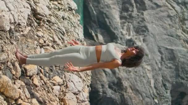 Yogi Κορίτσι Τεντώνει Λεπτό Σώμα Βραχώδη Θάλασσα Ηλιόλουστη Μέρα Κάθετα — Αρχείο Βίντεο