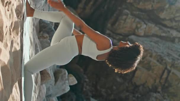Elastyczna Kobieta Ćwicząca Niskie Lonże Stwarza Skalistą Plażę Słoneczny Poranek — Wideo stockowe