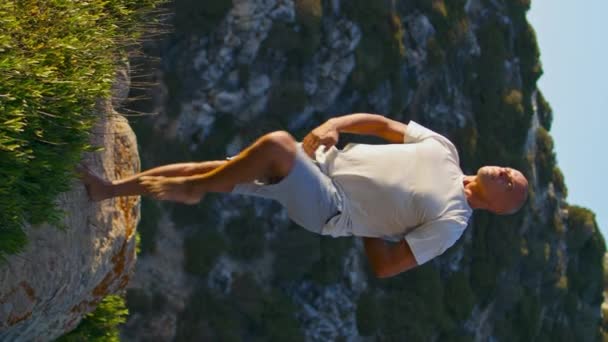 아름다운 해변에서 사나를 연습하는 건방진 근육질 선수가 햇살에 마스트 동작을 — 비디오