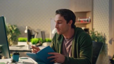 Akıllı öğrenci, bilgisayar görüntülerini yakın çekimde öğreniyor. Gülümseyen düşünceli adam masa başında oturup not defterine notlar yazıyor. Çevrimiçi webinar 'da sorulara cevap arayan serbest yazar