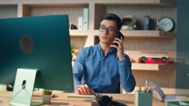 Kendine güveni tam bir acemi şirket ofisinde telefon görüşmesi yapıyor. Modern dolapta telefonla konuşan akıllı bir adam bilgisayar monitörü izliyor. Ciddi yönetici telefonda iş hakkında konuşuyor.
