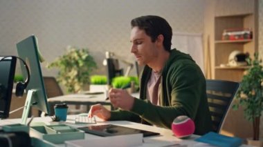 Düşünceli yaratıcı modern ofiste bilgisayar ekranını izliyor. Yakın plan grafik tasarımcısı ekolojik dairede fikirlere bakıyor. Serbest çalışan adam, Stylus 'u tablette yaratırken kullanıyor. Tasarım stüdyosu konsepti