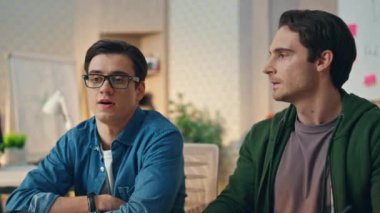 Sakin yaratıcılar ofis odasında bilgisayar ekranına bakıyor. Yakın plan gözlüklü yaratıcı iş adamı iş arkadaşıyla konuşuyor. Bilgisayar analizi projesinde birlikte çalışan iki odaklanmış ortak. Takım planlama stratejisi