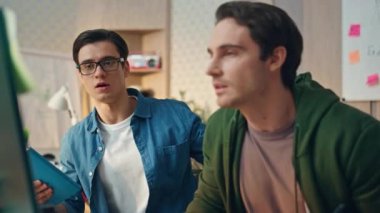 Dost canlısı ekip ofis odasında bilgisayarda birlikte çalışıyor. Kendine güvenen yönetici, fikir destekleyici takım arkadaşı olduğunu söylüyor. Gözlüklü adam uzaklaşıyor esmer adam geliştirici dikkatlice bakıyor.