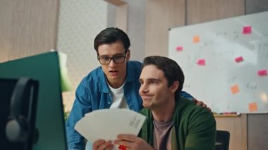 Ofisteki renkleri seçen ilham verici yaratıcılar. Yakın çekim gözlüklü yaratıcı iş adamı bilgisayar işyerinde iş arkadaşını destekliyor. İki tasarımcı birlikte beyin fırtınası yapıyorlar. Takım çalışması konsepti