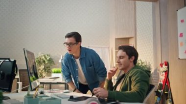 Ofis odasında çalışan mutlu takım bilgisayarı. Neşeli menajer takım arkadaşına fikrini söylüyor. İki serbest çalışan başarılı şirket sonuçlarını kabinede kutluyor 