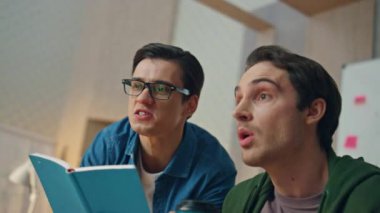 Ofiste bilgisayar ekranına bakan duygusal partnerler. Gözlüklü yaratıcı iş adamı meslektaşına notlar yazıyor. İki gülümseyen yaratıcı mutlu bir şekilde kamera görüntüsünü hareket ettiriyor.