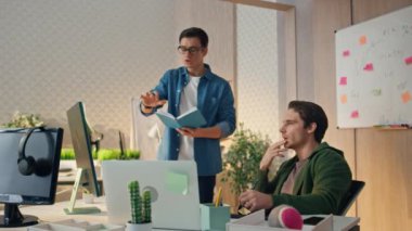 Yeni başlayanlar ofiste bilgisayar ekranını izliyorlar. İki uzman proje üzerinde çalışıyor. Toplantı odasında beyin fırtınası yapan yaratıcı insanlar. Gözlüklü adam not defteri işaret monitörü yazıyor.