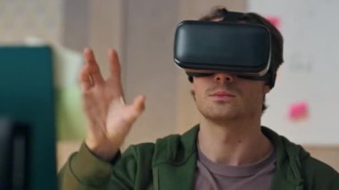 VR gözlük programını ofiste test eden yakın çekim adamı. Sanal gerçeklik kulaklığı, el hareketleriyle görünmez nesneleri içeri taşıyor. Sadece artırılmış gerçeklikte çalışan yaratıcı akıllı oyun tasarımcısı