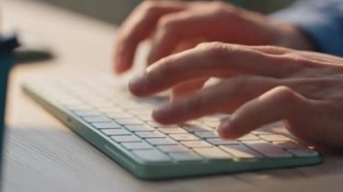 Masa kapanırken klavye çalışan bilgisayara mesaj atan erkek parmakları. Freelancer 'ın elleri ofiste internette gezinen tuşları yazıyor. Bilinmeyen işadamı uzaktaki işyerinde e-posta yazan tuşları itiyor 