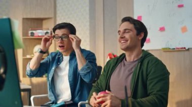 Modern ofisteki bilgisayardan konuşan olumlu adamlar. Yakın plan yaratıcı iş danışmanları masaüstü çevrimiçi toplantılarında sunum yapıyor. Gülümseyen iş arkadaşları projeyi tartışan monitöre bakıyor