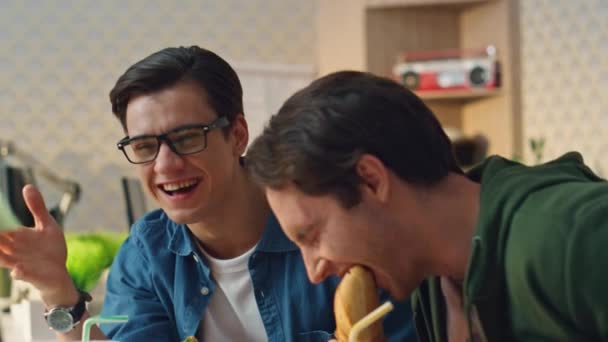 午餐的时候 男人们在情绪化的反应中大笑 最后分手了 现代设计师们在嬉皮士式的室内环境里吃面包 两位创作者在工作场所享受美食 有着良好的谈话气氛 — 图库视频影像