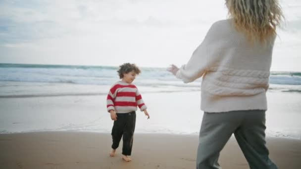 多云的日子 孩子们和父母一起玩秋天的海滩 赤脚卷曲的男孩与母亲共度春假 不知名的父母和可爱的孩子一起在海滨度假 童年快乐游戏的概念 — 图库视频影像