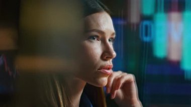 Kapalı devre kadın karanlık ofisteki hologram yansımasında borsa verilerini analiz ediyor. Düşünceli kadın satış komisyoncusu döviz istatistikleri kâr stratejisini kontrol ediyor. Ciddi yönetici görünümlü fikir.