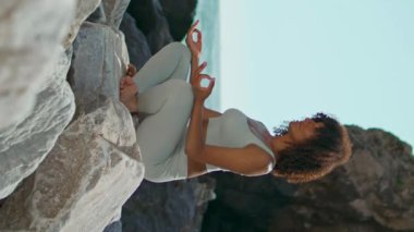 Nilüfer çiçekleri üzerinde meditasyon yapan sakin bir kadın oturarak taş gibi poz veriyor. Güzel Ursa plajı dikey olarak. Genç Afrikalı kız yaz doğasında yoga yapıyor. Sakin bir bayan, Asya 'da uyum ve sükunet hissediyor.