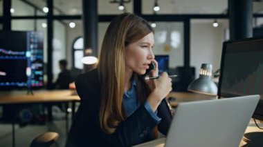 Finans işkadını lamba ışığında cep telefonundan konuşuyor. Başarılı bir yönetici şirketteki Forex stratejisini tartışıyor. Yatırım grafiğinde profesyonel borsacı uzmanı konuşan müşteri