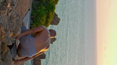 Adam güzel gün batımında baş yogası yapıyor. Okyanus kayalıklarında üstsüz antrenman yapan kaslı bir adam. Yoğunlaşan güçlü sporcu Rocky Beach 'te egzersiz yapıyor. Denge kavramı