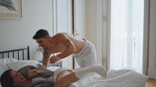 Yatakta Zıplayan Heyecanlı Adam Yatak Odasındaki Battaniyelerde Oynayan Neşeli Aşıklar — Stok video