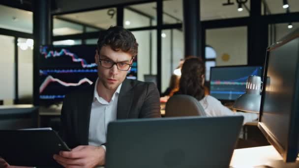 投資ブローカーは夕方のオフィスでデータを分析します 成功したビジネスマンの仕事のコンピュータ株式市場のデータ統計をチェックします プロのトレーダーは利益の計画を考える ヘッジファンドの投資家 — ストック動画